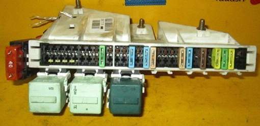 Detailansicht des Sicherungskastens im Kofferraum über der Batterie.