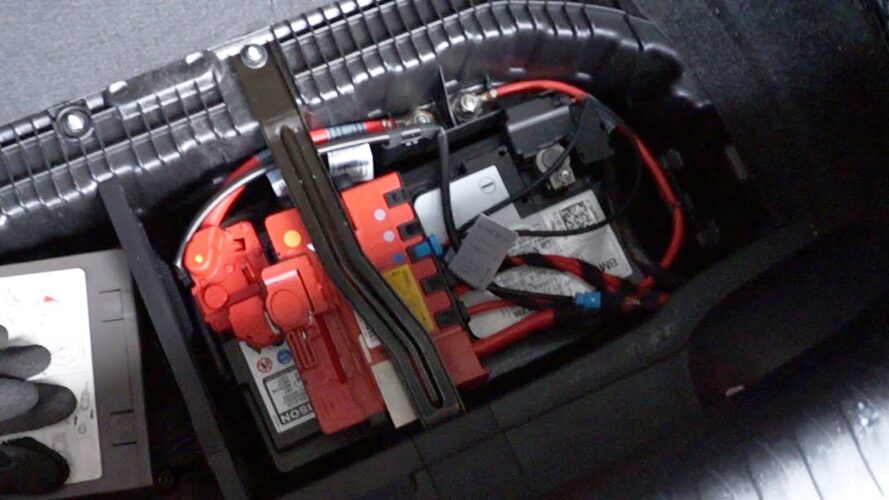 BMW 1er E87 Kofferraum mit angehobener Bodenmatte zur Batterieentnahme.